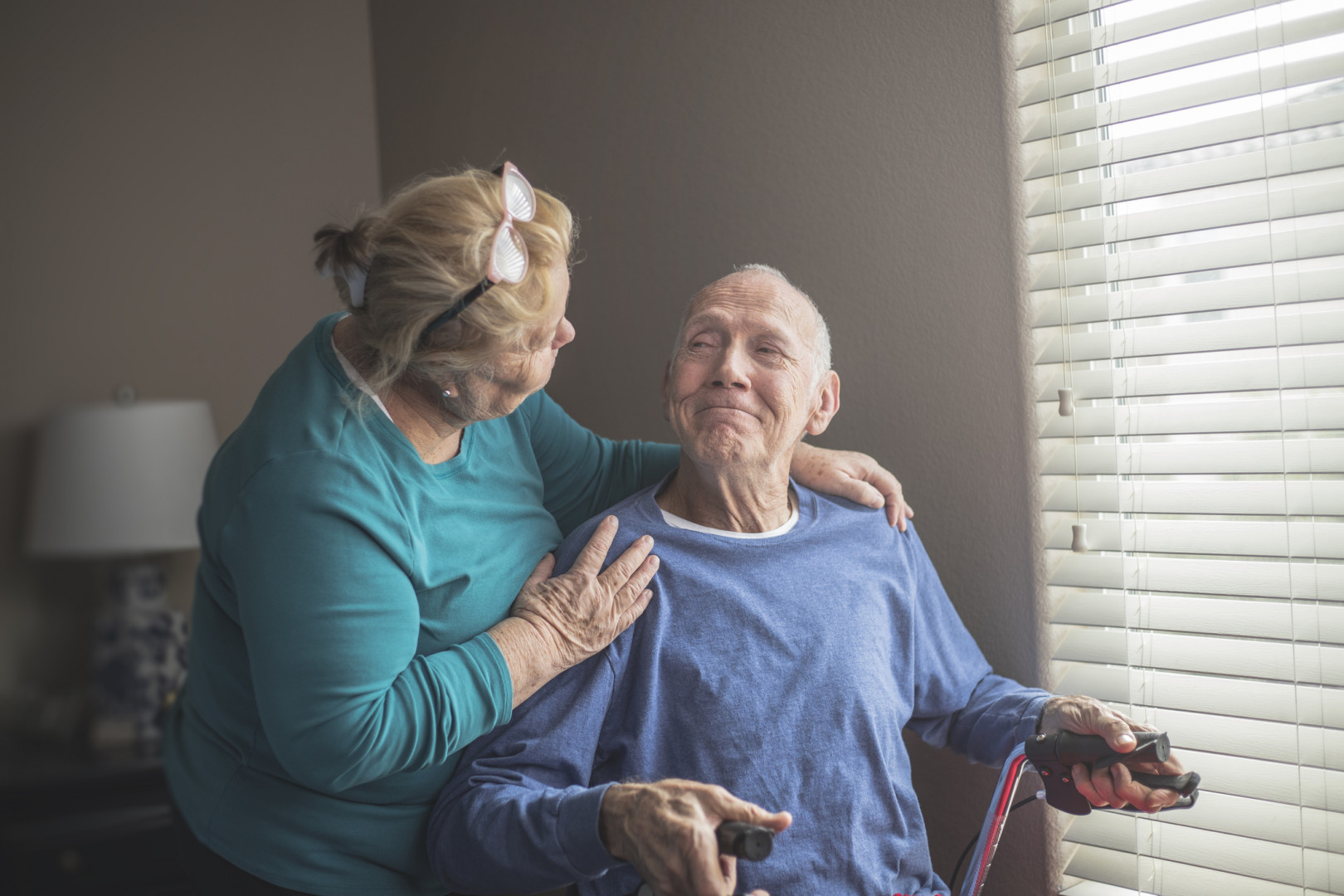 Elderly man sitting in a chair with their carer.