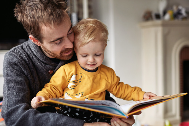 Father and son reading a book.