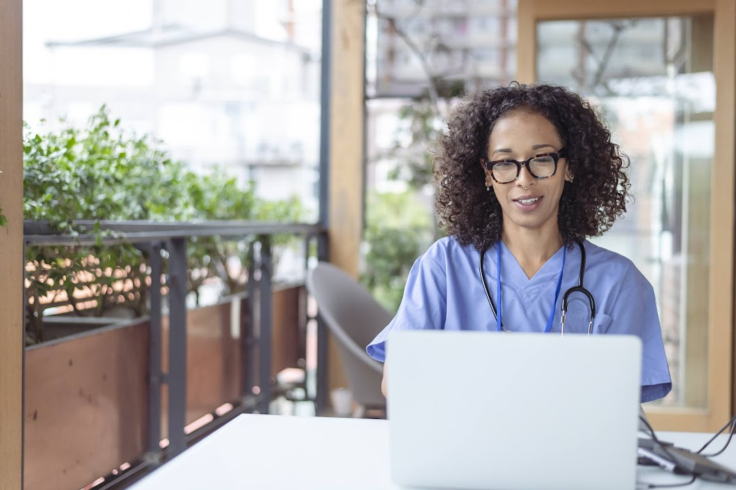 Health professional looking at laptop.