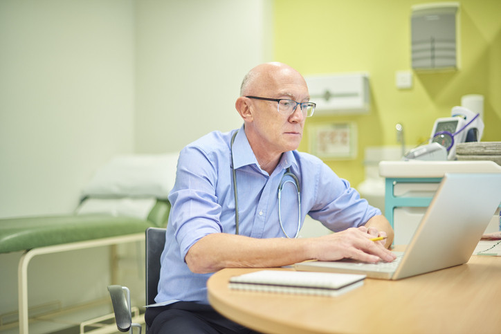 Male doctor on laptop.