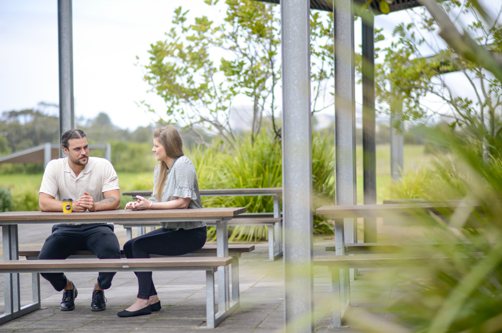 Two people sitting at a bench talking