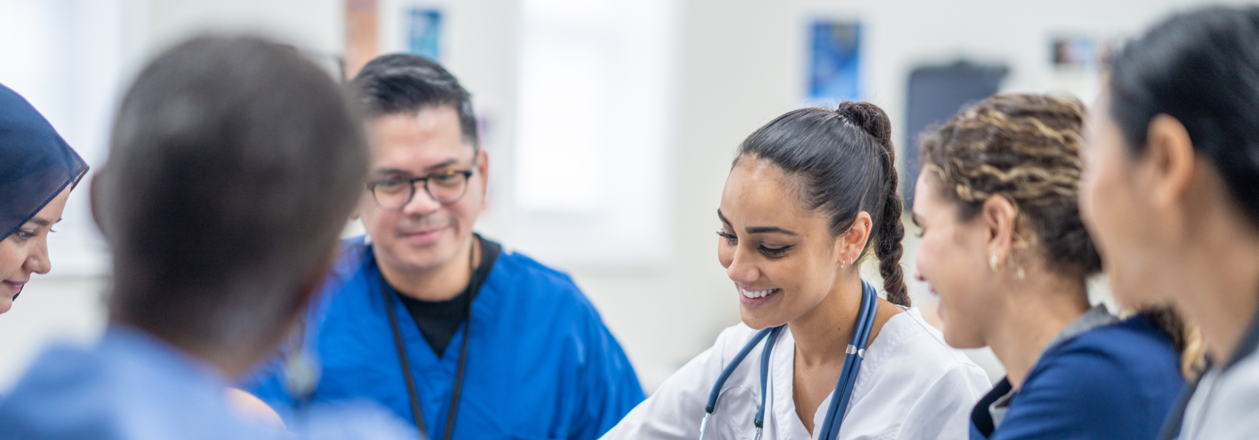 Health professionals speaking with each other whilst taking notes.