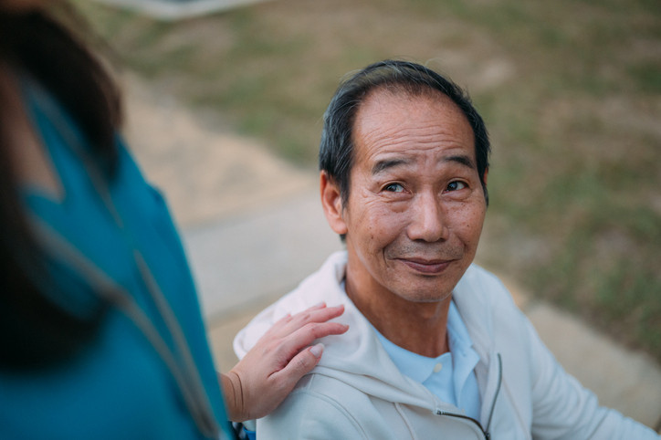 Elderly woman sitting with health professional.