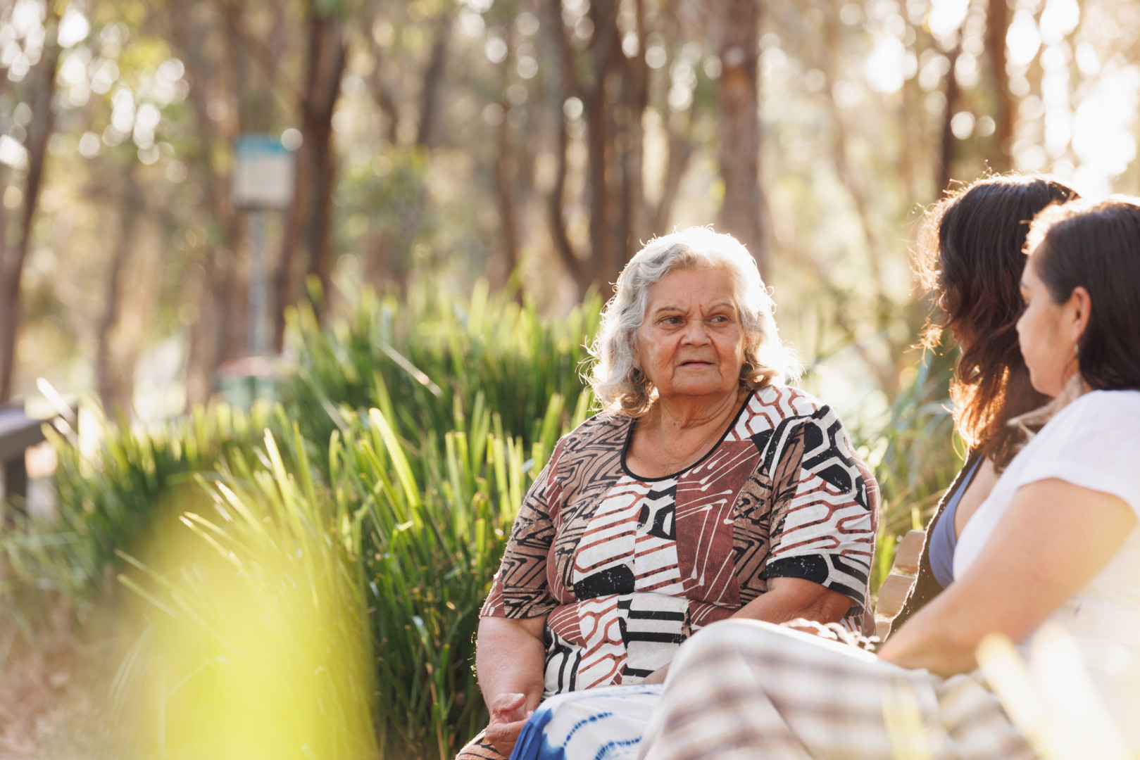 Aboriginal women smiling with each other whilst looking at a phone.