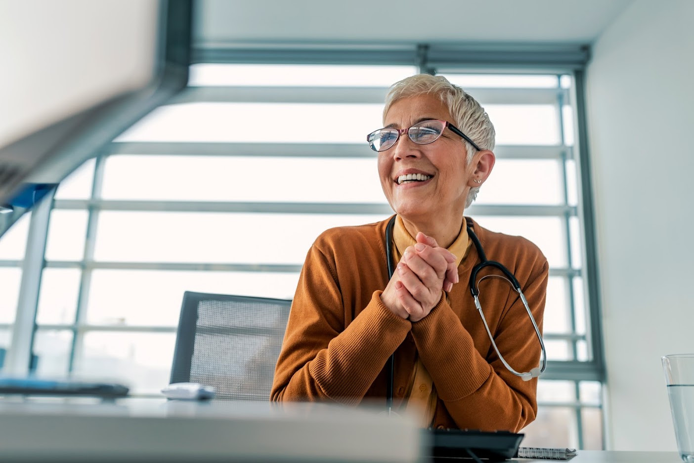 Female doctor smiling at desk.